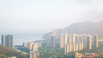 View of one of the districts of Sanya city. Visible are the skyscrapers. Sunset, blur, haze. Hainan Island, China.