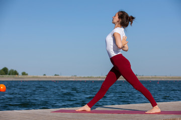 Pilates yoga workout exercise outdoor in the lake pier