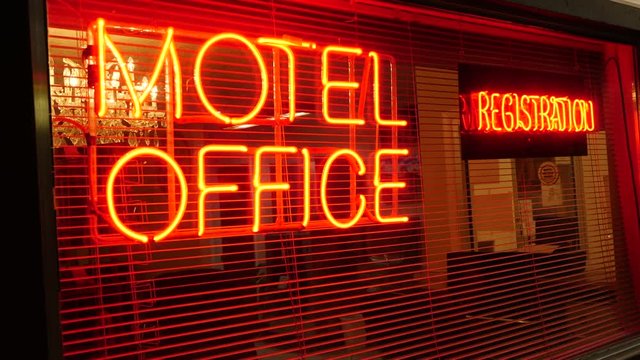 Close up shot of a Motel sign that signals the office and registration for check in.