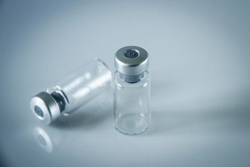 two vaccine bottles on grey background