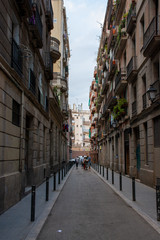 Fototapeta na wymiar Barcelona, Spain - 25th July 2017 - Long street with posts leading into the uknown