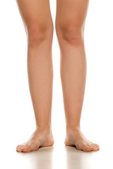 Front view of female barefoot legs on white background