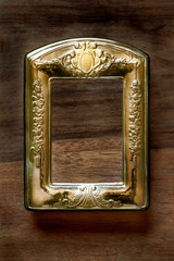 marco o portafoto dorado, oro, rectangular en fondo madera