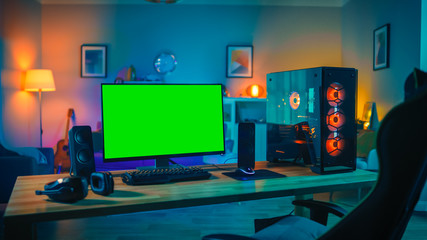 Powerful Personal Computer Gamer Rig with Mock Up Green Screen Monitor Stands on the Table at Home....