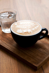 Hot latte with beautiful latte art on the wooden table