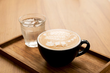 Hot latte with beautiful latte art on the wooden table
