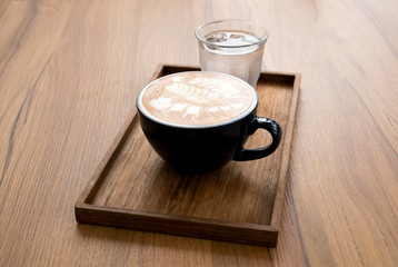Hot latte with beautiful latte art on the wooden table