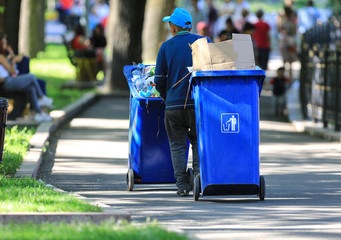 worker cleans garbage in the park