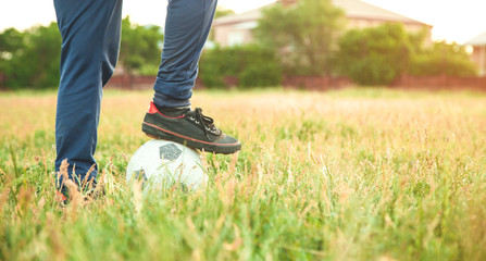 Caucasian boy with a soccer ball on a football field.