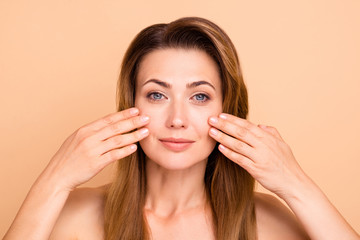 Close up photo beautiful amazing mature she her lady after anti-age procedures aesthetic pretty ideal appearance nude arms hands touch cheeks soft freshness perfect isolated pastel beige background
