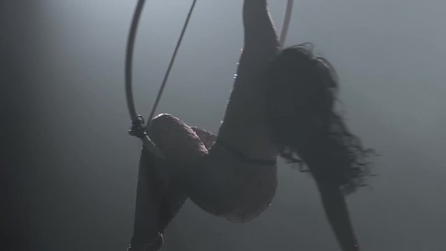 Young girl performs the acrobatic elements in the air ring. Slow motion. Closeup. 216