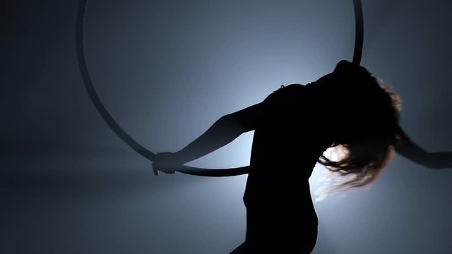 Silhouette Young girl performs the acrobatic elements in the air ring. Slow motion. Closeup. 253