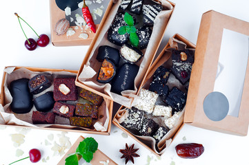 Sweet dessert candies handmade with various healthy fillings. in a craft box on a white background.