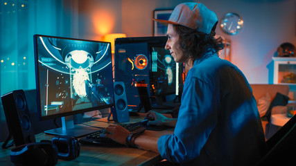 Professional Gamer Playing First-Person Shooter Online Video Game on His Powerful Personal Computer with Colorful Neon Led Lights. Young Man is Wearing a Cap. Living Room Lit with Warm Lamps. Evening. © Gorodenkoff