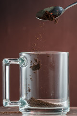 pouring natural coffee in a transparent glass mug, preparation for brewing