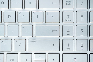 button on the gray silver keyboard of modern ultrabook close up. caption on the button