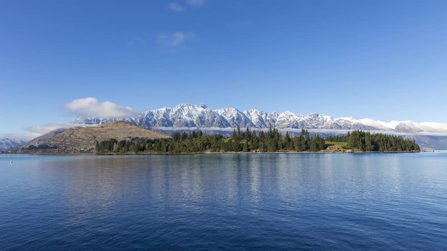 Time lapse of clouds rolling over the Remarkables and Lake Wakatipu sunny winter day in Queenstown, Otago, New Zealands