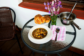 Table with mushroom soup, bread and vase.