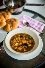 Forest mushroom soup, bread and pot on table.
