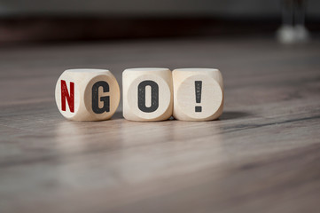Cubes and dice with No Go on wooden background