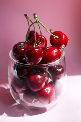 Cherries in transparent bowl, pink background. Red cherry. Fresh cherries. healthy food concept