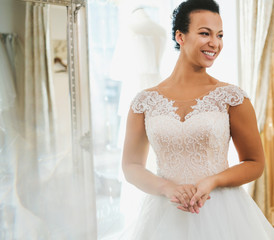 Beautifu bride choosing wedding dress in a wedding salon