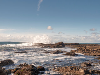 Huge wave crushes on stone coast line creating splash of water, Blue sky, Burren national park, Concept: power of nature.