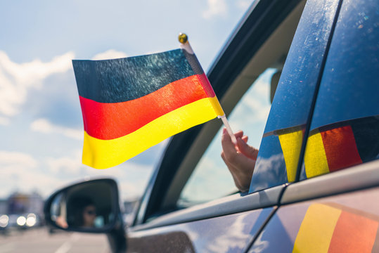 Woman or Girl Holding Germany Flag from the open car window. Concept