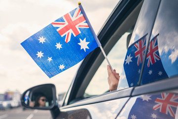 Woman or Girl Holding Flag of Australia from the open car window. Concept