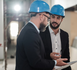 Engineers in hardhats have conversation