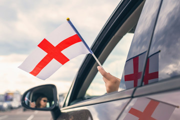 Woman or Girl Holding English Flag from the open car window. Concept