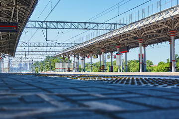 Empty railway platform with scoreboard on a sunny day.