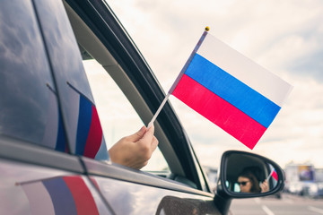 Woman or Girl Holding Russian Flag from the open car window. Concept