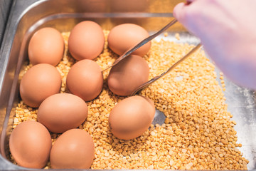 Woman choosing boiled eggs on a breakfast in a hotel restaurant.  Breakfast Buffet Concept