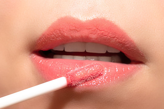 Woman Applying Liquid Lipstick Cream To Her Lips. Close Up.