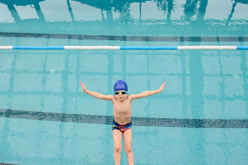 close up photo of 7-year boy preparing to jump in the swiimming pool
