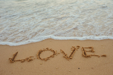 LOVE lettering on the beach with wave and sunlight