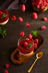 Panna cotta with raspberries on a dark background. Still life