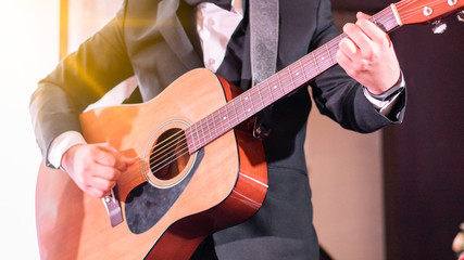 A man in a black dress is playing guitar.