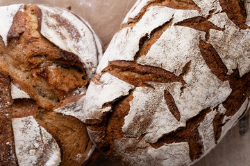 Assortment of baked bread on wooden table background.