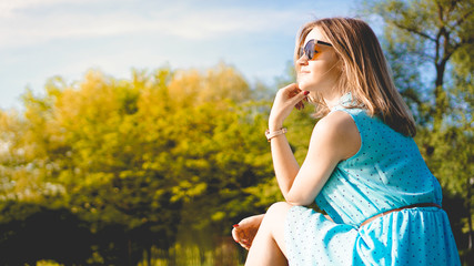 Obraz premium Young woman in sunny garden. Outdoor summer day. Meditation and freedom concept