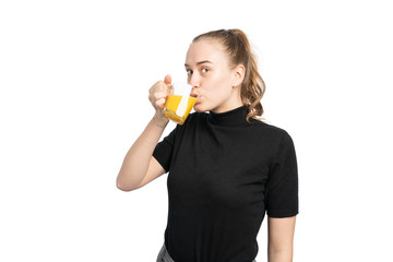 Fototapeta premium studio shot of a young woman drinking a glass of orange juice