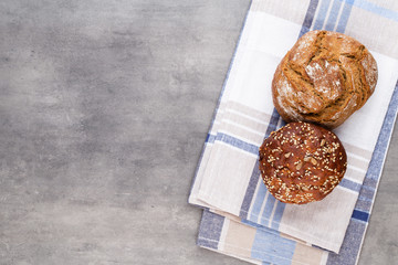 Gold rustic crusty loaves of bread and buns on wooden background. Still life captured from above top view, flat lay.