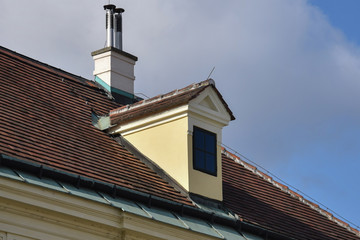 House with red clay tile roof and chimney.