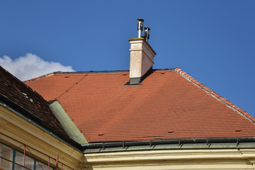 House with red clay tile roof and chimney.