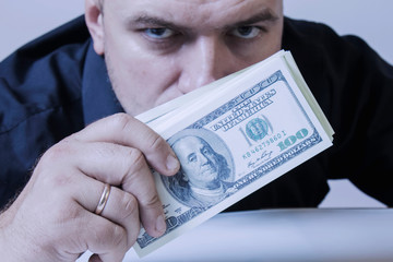 Man covering her mouth with a dollar banknote as symbol of bribery, cheating, financia and l ...
