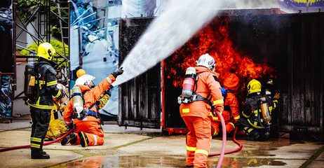 The Back side view of a group of teamwork  .firefighters helped stop the fire.