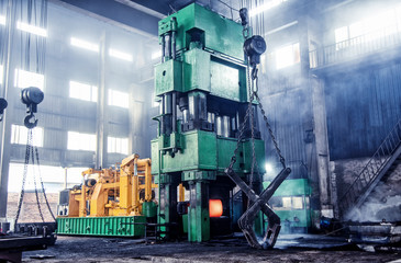 The metal forging press in the workshop is working.