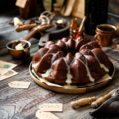 Delicious homemade chocolate bundt cake on wooden plate stands on rustic table