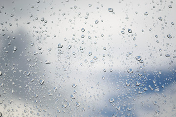 Creative idea for background. Raindrops on the glass against the sky